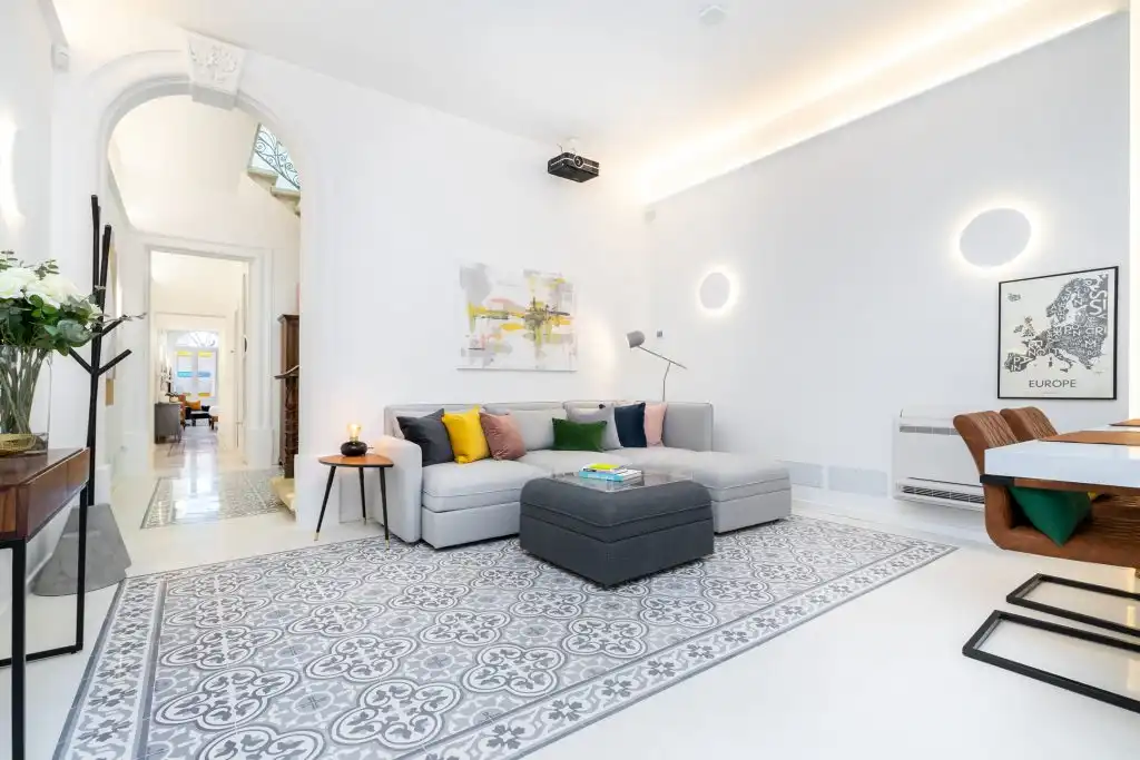 Living room at Aster House with patterned Maltese tiles and a ceiling projector