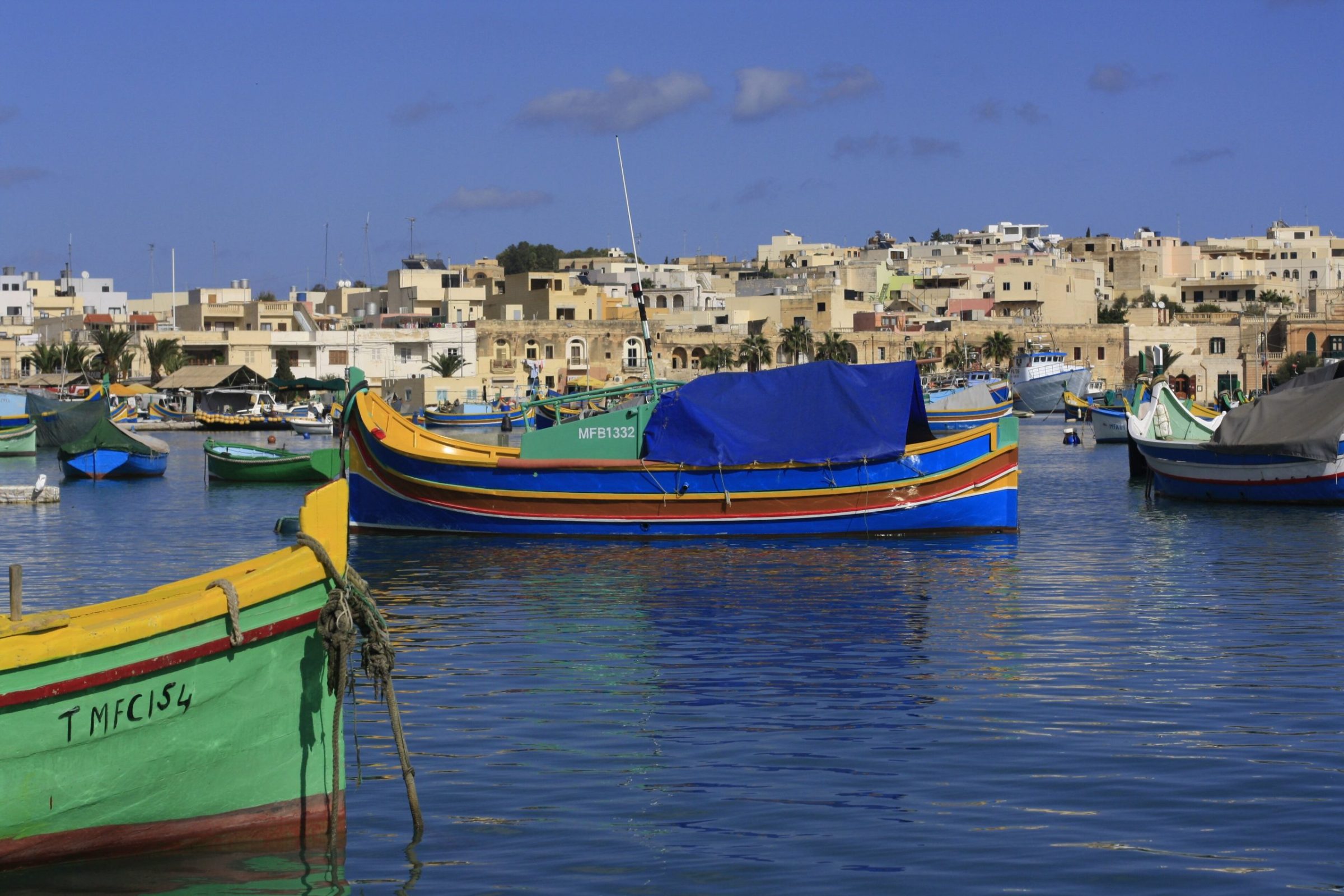 Colourful luzzu fishing boats in Marsaxlokk harbour, Malta