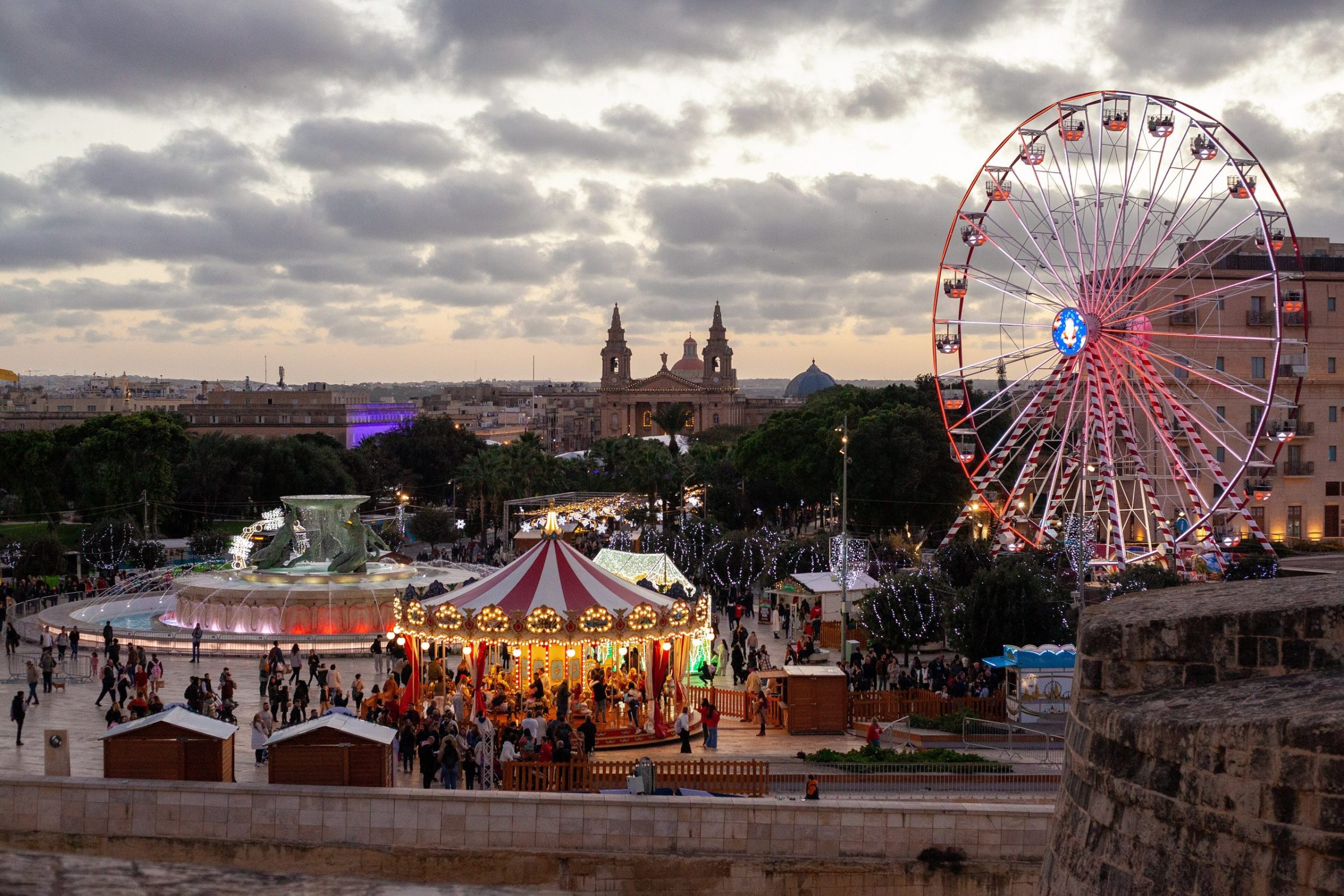 Christmas carousel, Ferris wheel and market stalls outside City Gate, Valletta